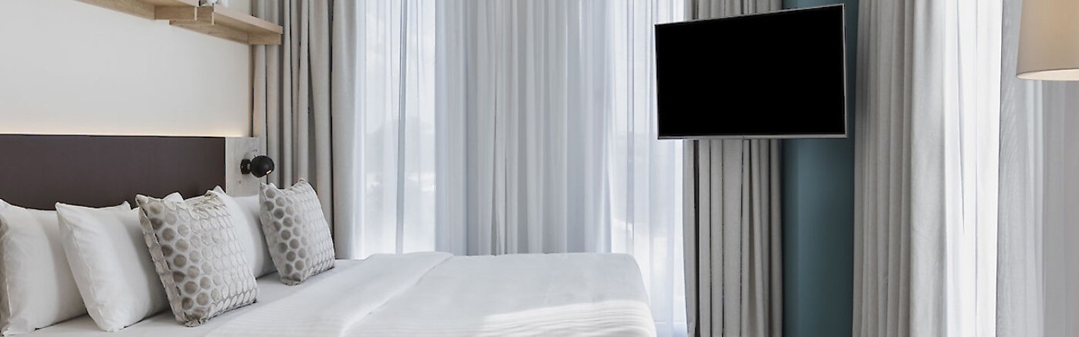 ein lichtdurchflutetes Schlafzimmer mit vielen Fenstern und viel Platz