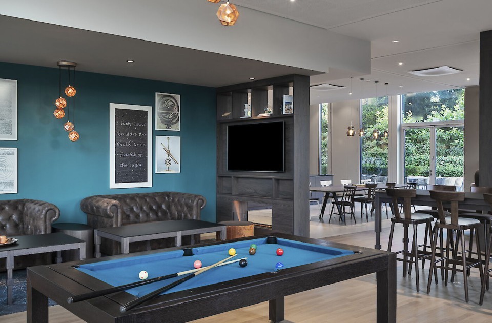 Hotellobby mit Billiardtisch und Sitzbereichen